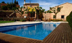 Solárium de madera junto a la piscina de la Masia Can Bellver