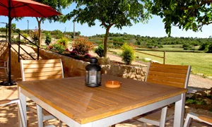 Terraza con mesa y vistas al valle en la Masia Can Bellver
